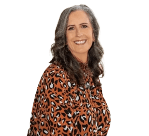 A woman in leopard print shirt smiling for the camera.