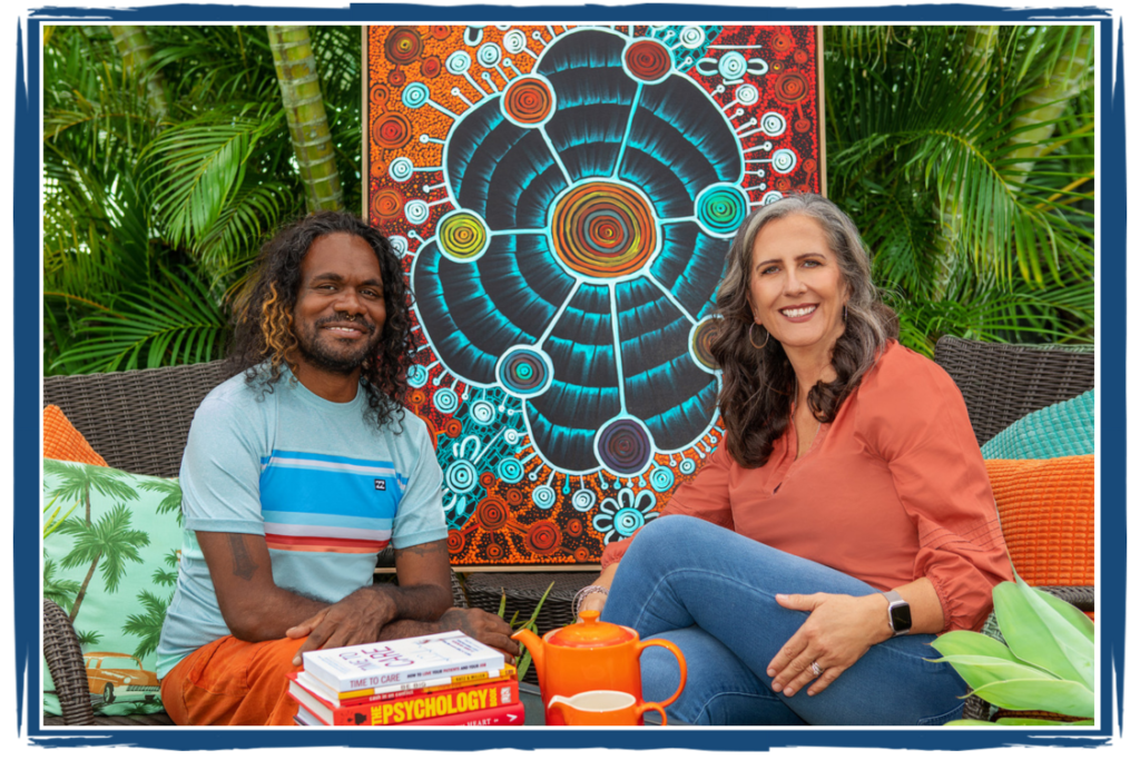 Two people sitting in front of a painting