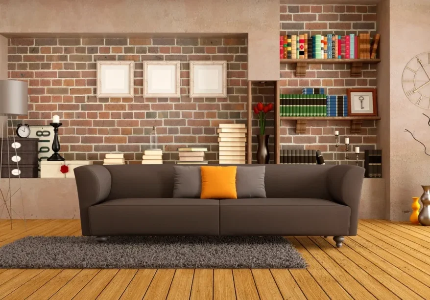 A living room with a couch and brick wall